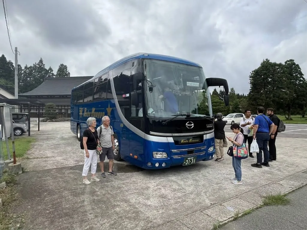 Pilgrims gathering beside their private coach at a sacred site in Japan