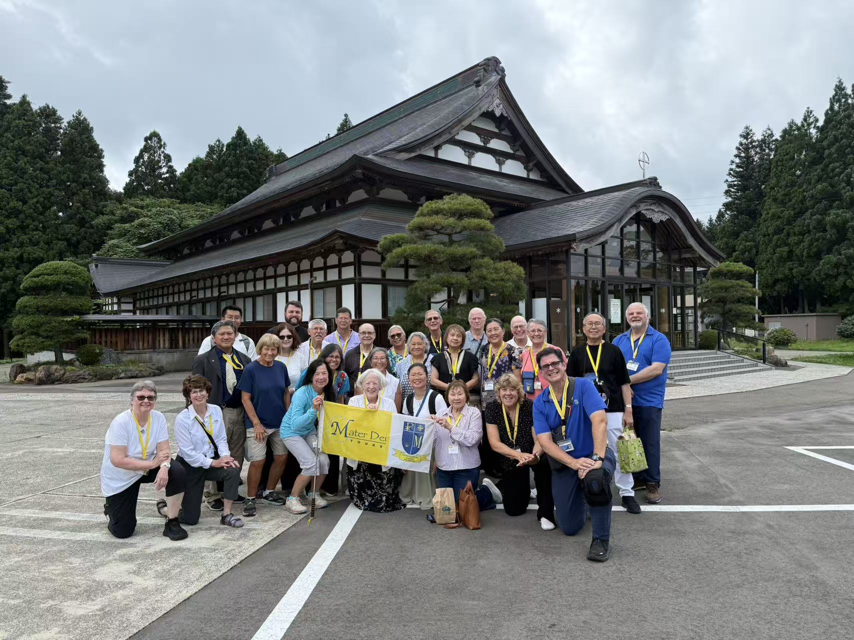 A Catholic pilgrimage group posing together outside a sacred site in Japan