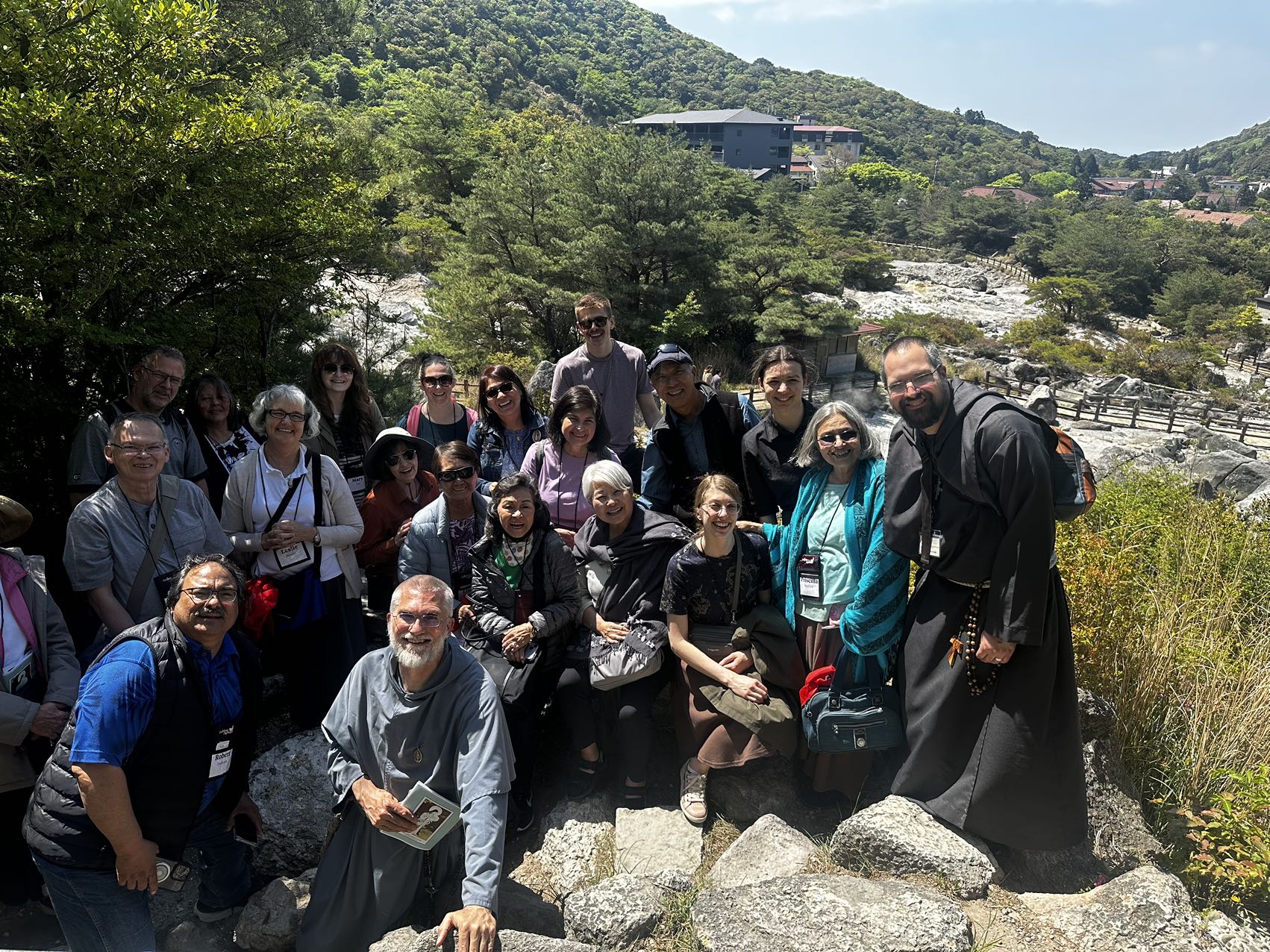 Catholic pilgrimage group posing together in a mountain landscape in Japan