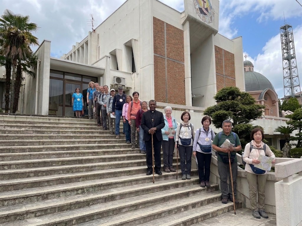 Pilgrimage group standing on the steps outside a church in Japan